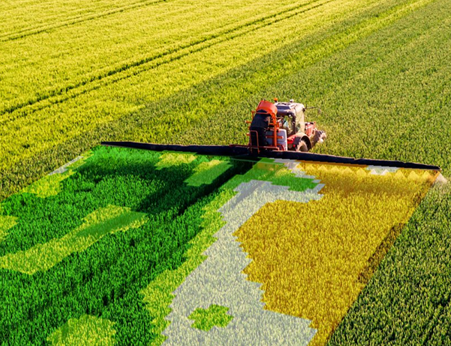Tractor performing precision spraying with variable-rate coverage in a field
