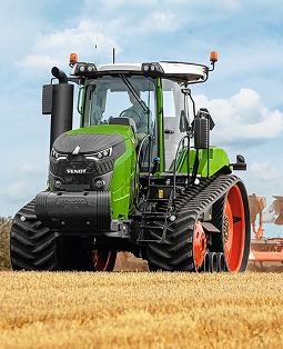 Green tractor close-up in a golden field